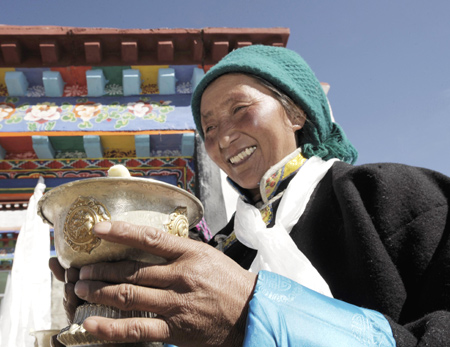 A Tibetan villager toasts during a ceremony for moving into her new house in Kunggar Town of Maizhokunggar County in Lhasa, capital of southwest China's Tibet Autonomous Region, on February 11, 2009. 