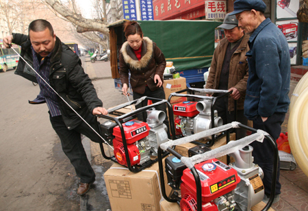 A farmer shops for water pump in Baofeng, central China's Henan Province, on February 11, 2009. Worst drought in decades has hit China's northern wheat-growing belt this spring. Affected residents were busy in fighting against the drought and reducing damages. 