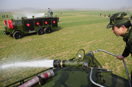 Soldiers help farmers water wheat in Liuwan Village of Nanyang, central China's Henan Province, on February 11, 2009.