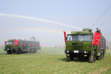 Soldiers help farmers water wheat in Liuwan Village of Nanyang, central China's Henan Province, on February 11, 2009.