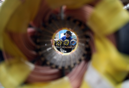 Workers fix electric pump machines in the workshop of a pump company in Yuncheng, north China's Shanxi Province, on February 12, 2009.