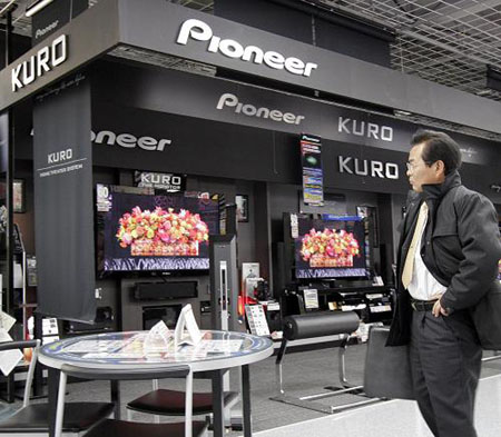 A customer looks at plasma display panel (PDP) televisions by Japanese electronics giant Pioneer at an electronics shop in Tokyo, on February12, 2009. Pioneer said it would withdraw from the TV business by March 2010, cutting 10,000 jobs worldwide, on February 12, 2009. 