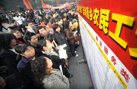 Migrant workers check job information on a job fair in Yichang, central China&apos;s Hubei Province, on February 12, 2009. 