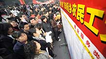 Migrant workers check job information on a job fair in Yichang, central China's Hubei Province, on February 12, 2009.