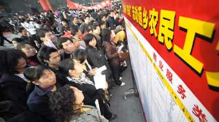 Migrant workers check job information on a job fair in Yichang, central China's Hubei Province, on February 12, 2009.