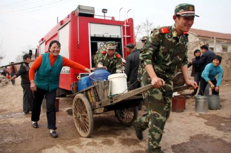 Soldiers help the villagers to transport water in Lieshan Township in Huaibei City, east China's Anhui Province, Feb. 12, 2009. Fire engines were sent to deliver water for residents in the villages of Lieshan Township. Huaibei city has suffered from drought since October last year. (Xinhua/Wan Shanchao)