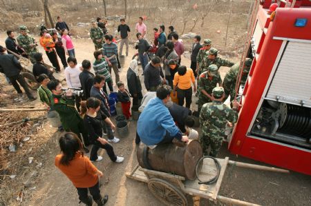 Villagers get water from a fire engine in Hualou Village of Lieshan Township in Huaibei City, east China's Anhui Province, Feb. 12, 2009. Fire engines were sent to deliver water for residents in the villages of Lieshan Township. Huaibei city has suffered from drought since October last year.