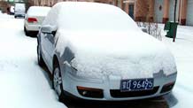 Cars covered with snow are shown in Chifeng City, north China's Inner Mongolia Autonomous Region, February 13, 2009. A snow hit the city from February 12, causing more than 400 passengers vehicles suspended and over 4,000 passengers delayed.