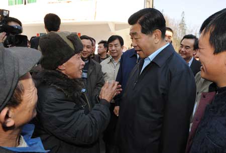 Jia Qinglin (R), chairman of the National Committee of the Chinese People's Political Consultative Conference, talks with villagers at Longbaotang Village of Xiannushan Township of Wulong County, in southwest China's Chongqing, on February 12, 2009. Jia Qinglin, also a member of the Standing Committee of the Political Bureau of the Communist Party of China Central Committee, surveyed Chongqing recently.