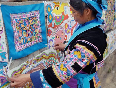 A woman of Miao ethnic group pastes her hand-made picture during a cultural activity held in Pingpo Village of Longli County, southwest China's Guizhou Province, on February 14, 2009.