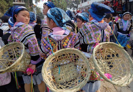 Girls of Miao ethnic group watch the performances during a cultural activity held in Pingpo Village of Longli County, southwest China's Guizhou Province, on February 14, 2009.