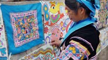 A woman of Miao ethnic group pastes her hand-made picture during a cultural activity held in Pingpo Village of Longli County, southwest China's Guizhou Province, on February 14, 2009.