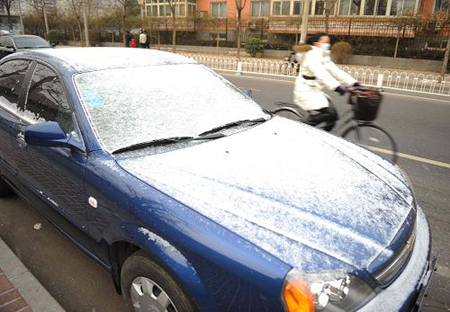 A car covered by snow is seen alongside a road in Beijing, capital of China, on February 17, 2009. 