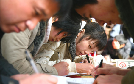 Chinese job hunters fill in application forms at a job fair for university graduates in rural Beijing on February 16, 2009. About 1.5 million university graduates in China failed to be employed by the end of the year of 2008 and another 6.11 million new graduates will seek jobs in the year of 2009 among the economic slump, worsening the government's endeavor to improve employment rate. 