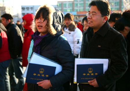 Two young Chinese with their diplomas queue up to enter a job fair for university graduates in rural Beijing on February 16, 2009. About 1.5 million university graduates in China failed to be employed by the end of the year of 2008 and another 6.11 million new graduates will seek jobs in the year of 2009 among the economic slump, worsening the government's endeavor to improve employment rate. 