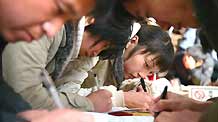 Chinese job hunters fill in application forms at a job fair for university graduates in rural Beijing on February 16, 2009. About 1.5 million university graduates in China failed to be employed by the end of the year of 2008 and another 6.11 million new graduates will seek jobs in the year of 2009 among the economic slump, worsening the government's endeavor to improve employment rate.