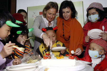 Ms. Cathleen Pecsteen (L), wife of the Consul General Mr. Marc Pecsteen of the Consulate General of the Kingdom of Belgium in Shanghai, and Judit Hajba (R), the culture attache of the Hungarian Consulate in Shanghai, cut the cake with leukemia-afflicted kids, at Tongji Hospital in Shanghai, east China's metropolis, on February 17, 2009. 