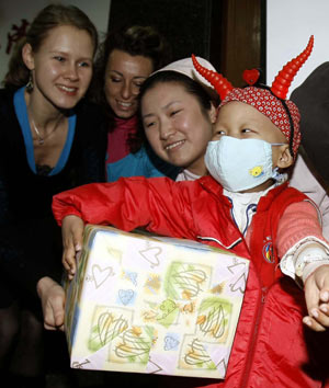 A leukemia-afflicted kid receives gift box from the international friendly visitors, at Tongji Hospital in Shanghai, east China's metropolis, on February 17, 2009.