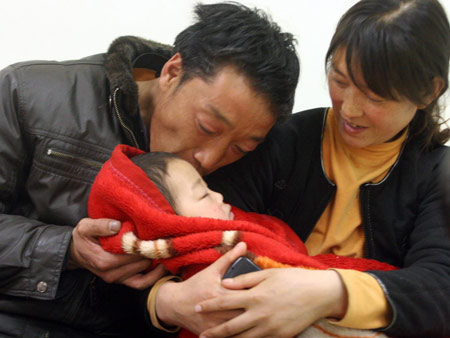 The 2-year-old leukemia-afflicted kid Li Rui is fondled and kissed by his parents, at the Beijing Children's Hospital in Beijing, China's capital, on February 17, 2009. 