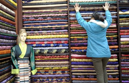 A young lady of Tibetan ethnic group selects cloth making traditional clothes of Tibetan ethnic group at a shop in Lhasa, capital of southwest China's Tibet Autonomous Region, on February 18, 2009. Traditional clothes of Tibetan ethnic group are popular among people of Tibetan ethnic group as Tibetan New Year, which falls on February 25 this year, is coming. 