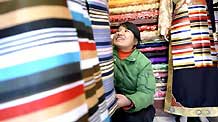 A young lady of Tibetan ethnic group selects traditional clothes of Tibetan ethnic group at a shop in Lhasa, capital of southwest China's Tibet Autonomous Region, on February 18, 2009. Traditional clothes of Tibetan ethnic group are popular among people of Tibetan ethnic group as Tibetan New Year, which falls on February 25 this year, is coming.