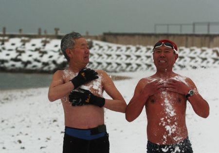 Two Chinese elders wash their body with winter snow prior to swim at an open pool during a snowfall in the costal city of Dalian, northeast China's Liaoning Province, on February 18, 2009. Rain and snowfall have helped ease a severe drought in northern and eastern China. 