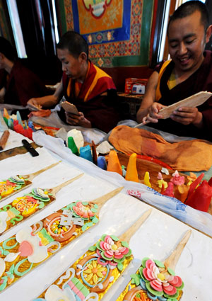 Tibetan lamas make colorful plates at a lama temple in Lhasa, capital of southwest China's Tibet Autonomous Region, on February 19, 2009. These plates are made from butter and will be inserted on Qiema, a two-tier rectangular wooden box containing roasted barley and food prepared with butter, parched barley meal and sugar. Local people are making preparation for the Tibetan New Year, which falls on February 25. 