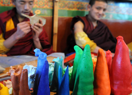 Tibetan lamas make colorful plates at a lama temple in Lhasa, capital of southwest China's Tibet Autonomous Region, on February 19, 2009. 