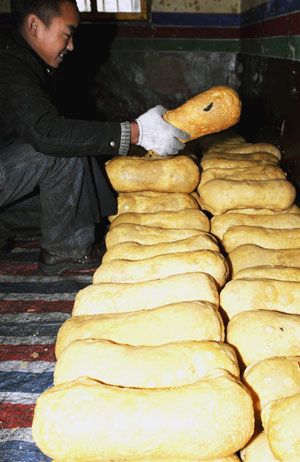 A Tibetan lama prepares a kind of traditional fried cake at a lama temple in Lhasa, capital of southwest China's Tibet Autonomous Region, on February 19, 2009. 