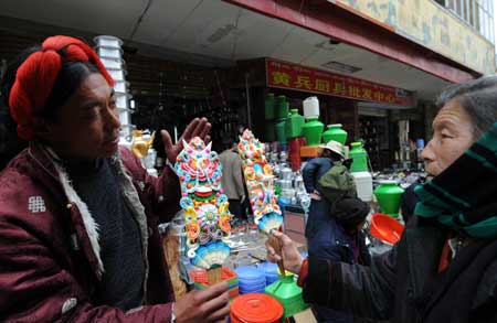 A man sells color plates, which are necessary tools for the Tibetan New Year, at a market in Lhasa, capital of southwest China's Tibet Autonomous Region, on February 22, 2009. Traditional goods for the Tibetan New Year are still popular at the market in Lhasa, as the new year draws near. 