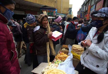 A Tibetan woman buys traditional goods for the Tibetan New Year, at a market in Lhasa, capital of southwest China's Tibet Autonomous Region, on February 22, 2009. Traditional goods for the Tibetan New Year are still popular at the market in Lhasa, as the new year draws near.