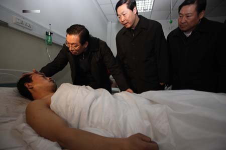 Luo Lin (1st L, rear), head of the State Administration of Work Safety, Zhao Tiechui (R, rear), head of the State Bureau of Coal Industry, and Zhang Baoshun (C, rear), the Provincial Communist Party Committee chief, talk with a miner injured during the accident at a hospital Gujiao City, north China's Shanxi Province, on February 22, 2009.