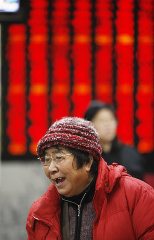 A stock holder reacts in front of a board displaying the Shanghai Composite Index in Shanghai, China, on February 23, 2009. 