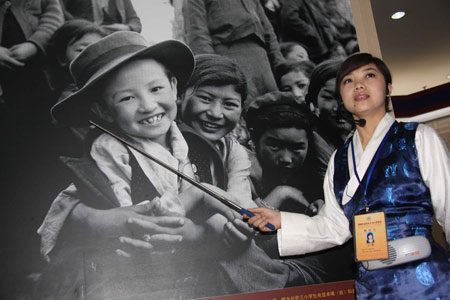 A guide introduces a photo in an exhibition marking the 50th anniversary of the Democratic Reform in Tibet Autonomous Region in Beijing, China, on February 24, 2009. 