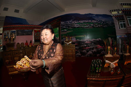 A Tibetan woman greets visitors in an exhibition marking the 50th anniversary of the Democratic Reform in Tibet Autonomous Region in Beijing, China, on February 24, 2009. 