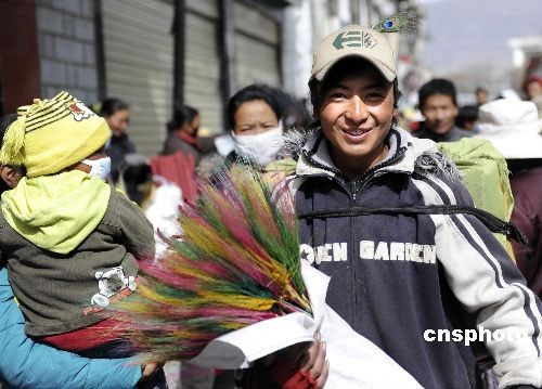 A young man in Lhasa, capital city of southwest China's Tibet Autonomous Region, carries home on Monday a bunch of colored spikes, a traditional decoration for the Tibetan New Year, which falls on February 25, on the Tibetan lunar calendar. 