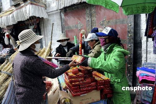 A woman buys firecrackers at a bazaar near the Ramoche Temple in Lhasa, capital of Tibet Autonomous Region on February 23, 2009. Residents in Lhasa are preparing for their Tibetan New Year which falls on February 25. 