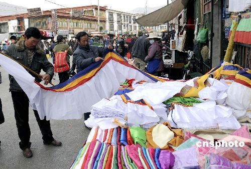 A cloth shopowner measures cloth for a customer at a bazaar near the Ramoche Temple in Lhasa, in Tibet Autonomous Region on February 23, 2009. Residents in Lhasa are preparing for the Tibetan New Year which falls on February 25.