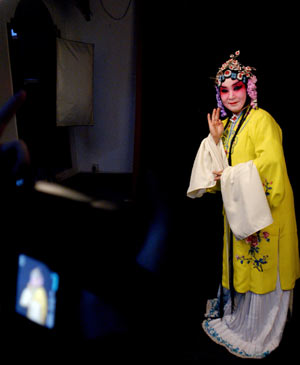 A lady, with her dressing and face-painting in Beijing Opera style, poses for pictures at a studio in the provincial city of Jinan, east China's Shandong Province, on February 25, 2009. Costume and face-painting in Beijing Opera style attracted more and more fans and youth to the studio for taking a series of memorial pictures.