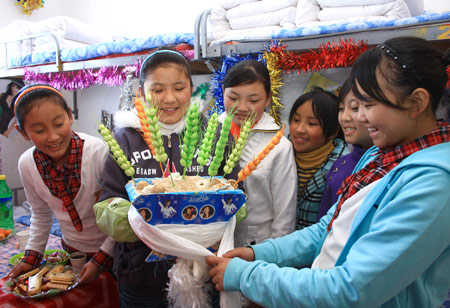 Students of Tibetan ethnic group decorate Qiema, a rectangular wooden box containing roasted barley, and highland barley, which symbolizing great harvest for the coming new year at Liaoyang First High School in north China's Liaoning Province on February 25, 2009. Tibetans across China are celebrating the 50th Tibetan New Year after the Democratic Reform with their old traditions.