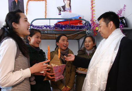 A teacher (R) congratulates Tibetan students in Tibetan style on the first day of Tibetan new year at Liaoyang First High School in north China's Liaoning Province on February 25, 2009. Tibetans across China are celebrating the 50th Tibetan New Year after the Democratic Reform with their old traditions.