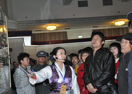 A guide introduces photos at an exhibition marking the 50th anniversary of the Democratic Reform in Tibet Autonomous Region in Beijing, on February 25, 2009. 