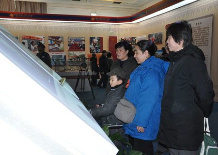 Visitors read an electronic book on the history of Tibet at an exhibition marking the 50th anniversary of the Democratic Reform in Tibet Autonomous Region in Beijing, on February 25, 2009. 