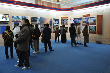 Photo taken on February 26, 2009 shows visitors watch pictures and videos at the third hall of the 50th Anniversary of Democratic Reforms in Tibet Exhibition, which runs from February 24 to April 10 at the Exhibition Center of the Cultural Palace of Nationalities, Beijing. 