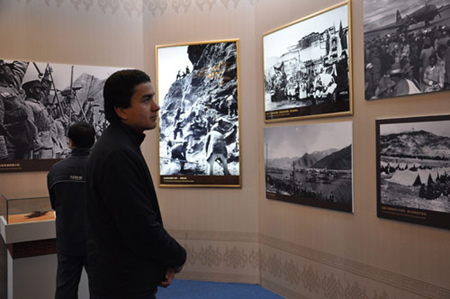 Photo taken on February 26, 2009 shows a Uigur young man watches pictures about the peaceful liberation of Tibet at the 50th Anniversary of Democratic Reforms in Tibet Exhibition, which runs from February 24 to April 10 in the Exhibition Center of the Cultural Palace of Nationalities, Beijing. 