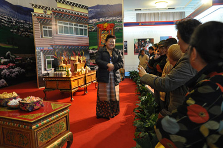 Photo taken on February 26 shows visitors ask a guide questions about custom and habits appear during the Tibetan New Year in the third hall of the 50th Anniversary of Democratic Reforms in Tibet Exhibition, which runs from February 24 to April 10 at the Exhibition Center of the Cultural Palace of Nationalities, Beijing.