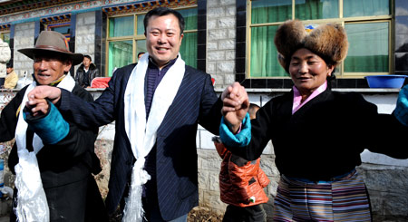 Liu Shengjie (C), a cadre from Beijing, dances with his Tibetan friends during the celebration of the Tibetan New Year in Lhasa, capital of southwest China's Tibet Autonomous Region, on February 26, 2009, the second day of the 'earth ox' year on the Tibetan calendar. Officials coming from interior areas to aid the region celebrated the Tibetan New Year together with local Tibetans.