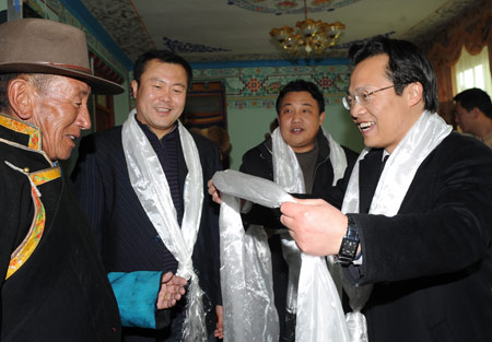 Sun Deyue (1st R), a cadres from Beijing, who is the Doilungdeqen County's party secretary, presents Hada to his Tibetan friend during the Tibetan New Year celebration in Lhasa, capital of southwest China's Tibet Autonomous Region, on February 26, 2009, the second day of the 'earth ox' year on the Tibetan calendar. Officials coming from interior areas to aid the region celebrated the Tibetan New Year together with local Tibetans.