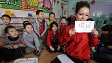A teacher of Uygur ethnic group teaches Chinese characters to children at a kindergarten in Urumqi, capital of northwest China's Xinjiang Uygur Autonomous Region, on February 26, 2009. This kindergarten offers bilingual education to pre-primary school children of local Uygur people.