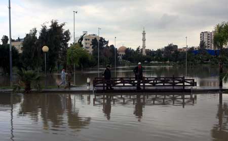 Palestanian people walk through the flooded street after a rainstorm in Gaza City, on March 1, 2009. 